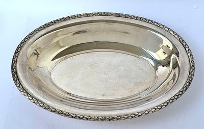 an antique silver plate on a white table with a white background