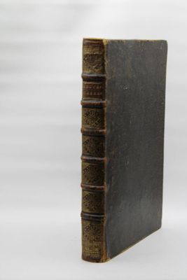 un vieux livre posé sur une table à côté d'un fond blanc