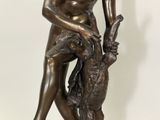 statue en bronze représentant un garçon avec un lapin, posée sur un socle