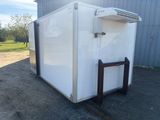 a white refrigerator sitting outside of a building with a window