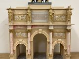 a small model of a building on a wooden table