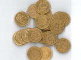 une pile de pièces d'or posée sur une surface blanche