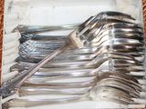 a lot of forks and spoons sitting on a tray