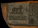 an image of a plaque on a piece of wood with a picture of a castle