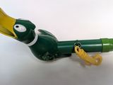 a green toy duck with a yellow beak on it ' s head