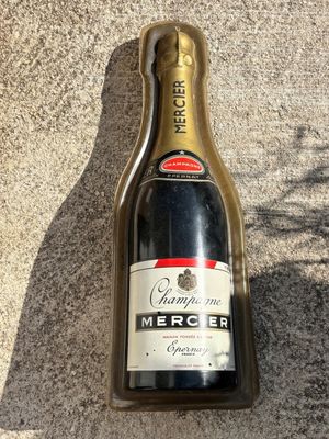 une bouteille de champagne vide posée par terre à côté d'une bouteille de vin