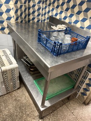 a metal table with a basket on top of it