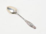 silver spoon on a white surface with a silver spoon in the middle of it