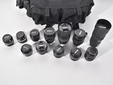 a lot of camera lenses and a bag on the table