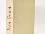 an old book sitting on top of a white table next to a white wall
