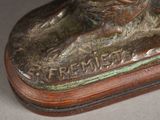 a bronze statue of a horse on a wooden base