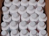 a cardboard box filled with white bottles of water