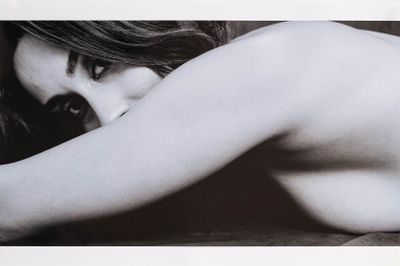 une photo en noir et blanc d'une femme nue allongée sur un lit
