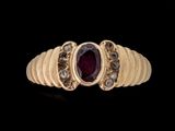 gros plan d'une bague en or avec une pierre en rubis