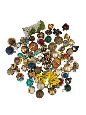 a pile of assorted jewelry on a white surface
