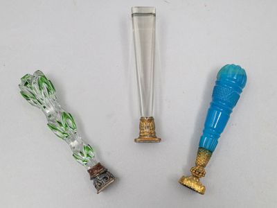 trois types différents d'objets en verre posés sur une surface blanche