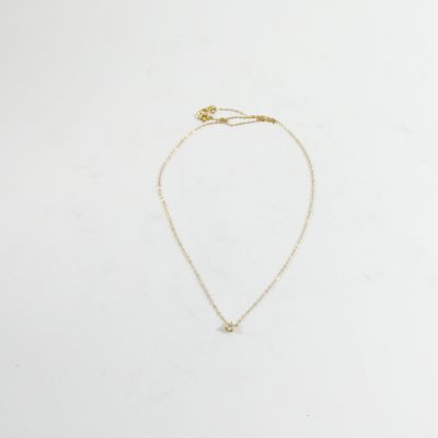 un collier en or avec un petit diamant suspendu à une chaîne