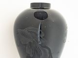 a black vase with a picture of a woman on it