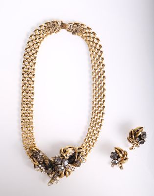 une photo d'un ensemble composé d'un collier et de boucles d'oreilles sur fond blanc