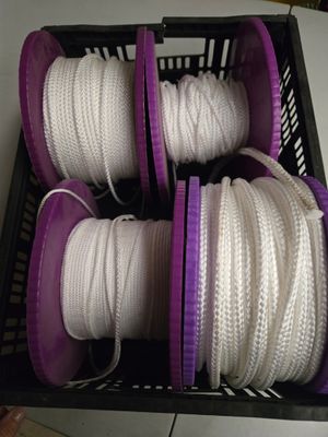 un panier rempli de cordes blanches et violettes posé sur une table