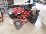 une tondeuse à gazon rouge posée par terre dans un garage