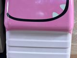 une valise rose et blanche avec un smiley dessiné dessus