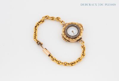 an image of a gold wrist watch with a chain around it