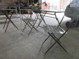 plusieurs chaises pliantes et une table dans un garage, avec un camion en arrière-plan