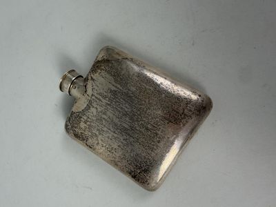 a small silver flask on a white surface