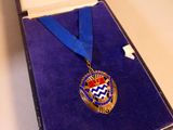 une médaille dans une boîte, entourée d'un ruban bleu