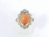 un gros plan d'une bague ornée d'une pierre orange entourée de diamants