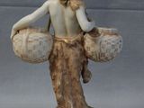 a figurine of a woman holding two baskets