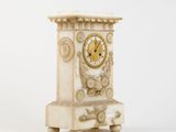 a white clock that is sitting on a table