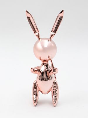 a pink rabbit figurine sitting on top of a white surface