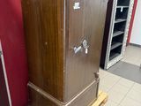 a wooden cabinet sitting on a pallet next to a red wall