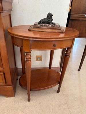 une petite table sur laquelle est posé un livre, à côté d'une commode