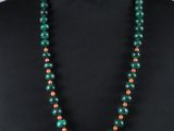 un collier de perles vertes et orange sur un mannequin