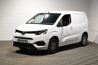 La camionnette blanche est garée dans une pièce blanche au sol à carreaux.