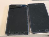 two cell phones sitting on a table next to each other