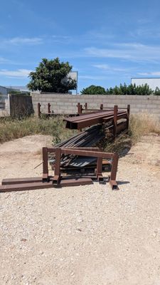 un tas de métal par terre, près d'une clôture