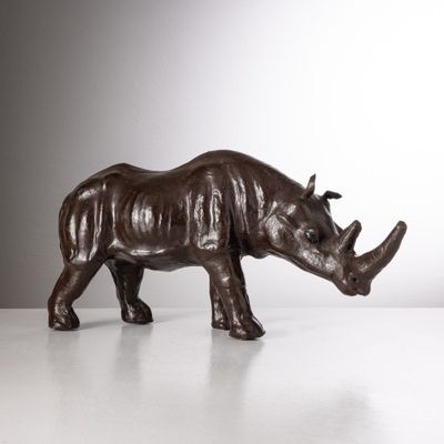 sculpture en bronze représentant un rhinocéros debout sur une surface blanche
