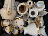 a lot of white and gold coffee cups and saucers in a box