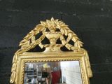 a mirror that has a gold frame on it