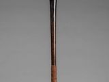 an old wooden stick with a wooden handle on a gray background