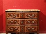 une commode en bois dans une pièce aux murs rouges