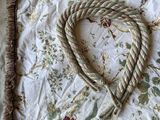 a heart made out of a rope on a bed