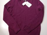 a close up of a purple sweater with a tag on it