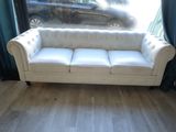 a white couch sitting in front of a window in a living room