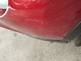 a close up of a red car that has been dented