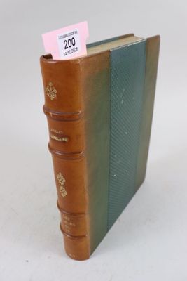 un livre marron à la couverture verte posé sur une table blanche